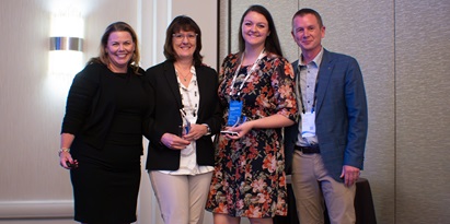 Presenter Kelly Woodsum (far left) and Richard Steward, EVP Americas Software, Körber Business Area Supply Chain (far right) with honorees Miriam Steuart (center left) and Brianna Henthorn of Ecolab (center right) for a photo op 
